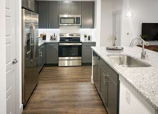 A modern kitchen with a stainless steel refrigerator and oven.