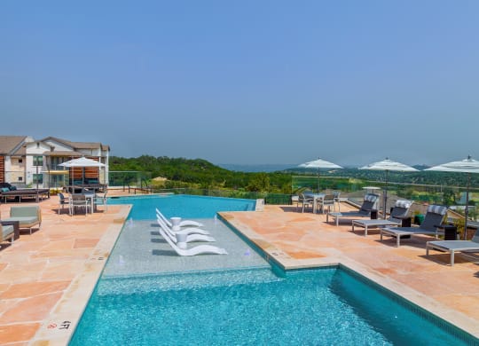 a swimming pool with chairs and umbrellas at a resort