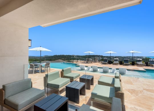 a view of a swimming pool with tables and chairs and umbrellas
