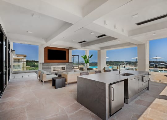 a large living room with a kitchen and a television
