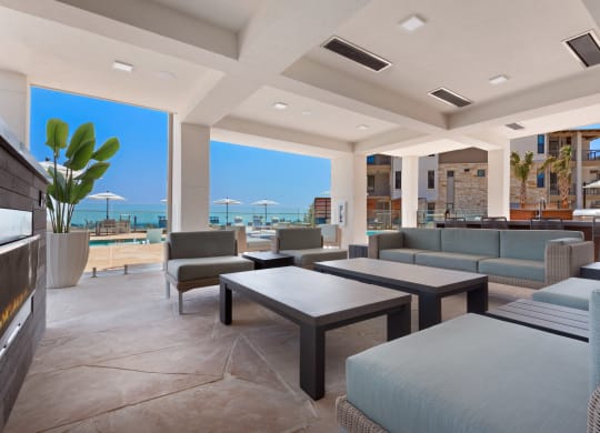 a living room with couches and tables and a view of the ocean