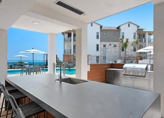 a kitchen with a sink and a counter top overlooking a pool