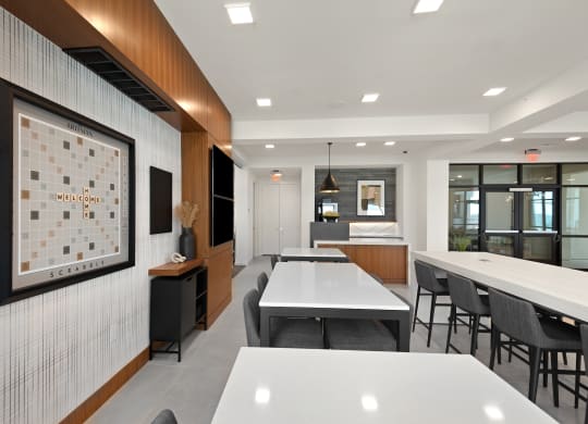 a communal area with tables and chairs and a bulletin board