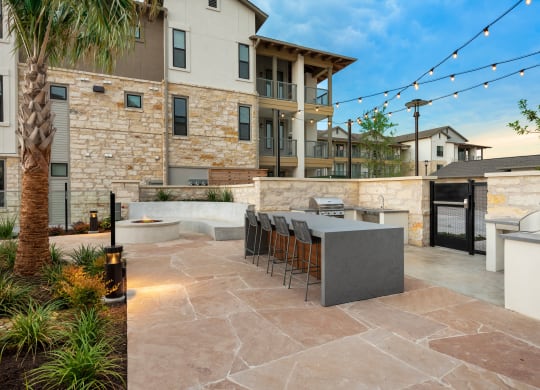 a patio with a bar and a building with lights