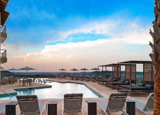 a swimming pool with chairs and umbrellas at a resort