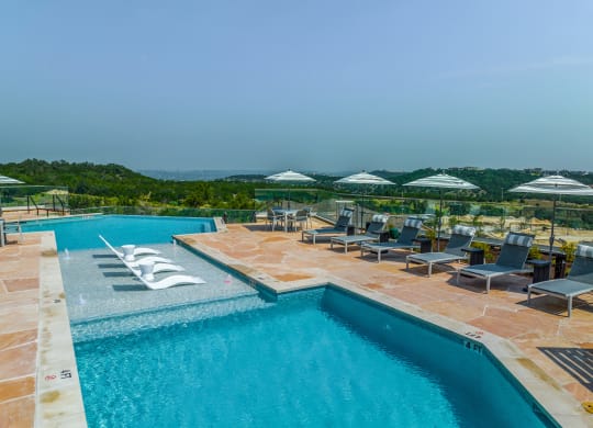 a swimming pool with chairs and umbrellas at a resort
