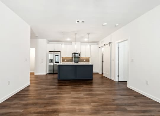 a kitchen with white walls and a black island in the middle of it