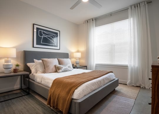 an empty bedroom with a bed and a window