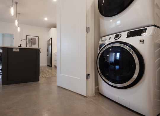 a front loading washer and dryer in a kitchen next to a laundry room