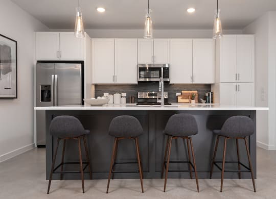 a kitchen with a large island with three stools