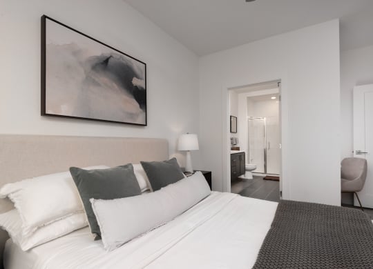 a bedroom with a large bed and a painting on the wall