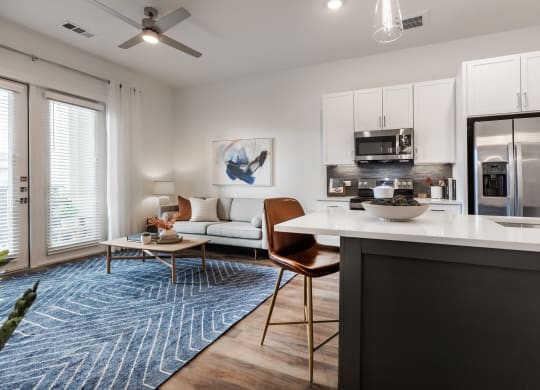 an open living room and kitchen with a refrigerator and a microwave