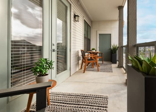 a balcony with a table and chairs and sliding glass doors