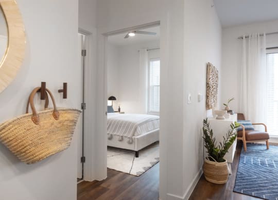 a bedroom with a bed and a woven basket hanging on the wall