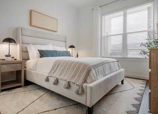 a bedroom with a bed and two windows