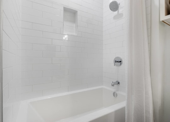 a white bathroom with a shower and a tub