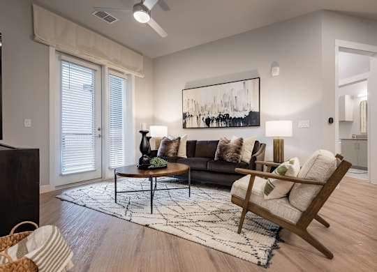 A living room with a couch, a coffee table, and a painting on the wall.