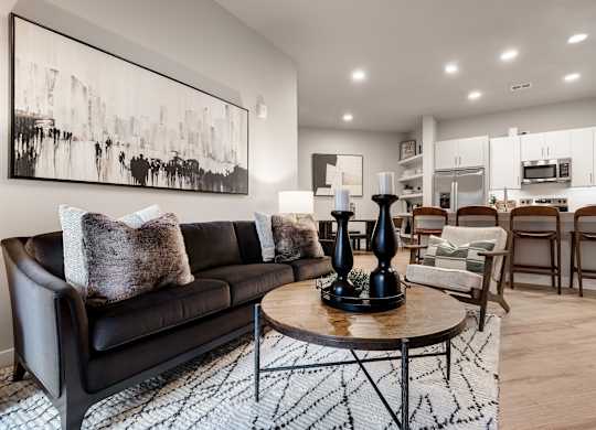 A black leather sofa with a wooden coffee table in front of it.