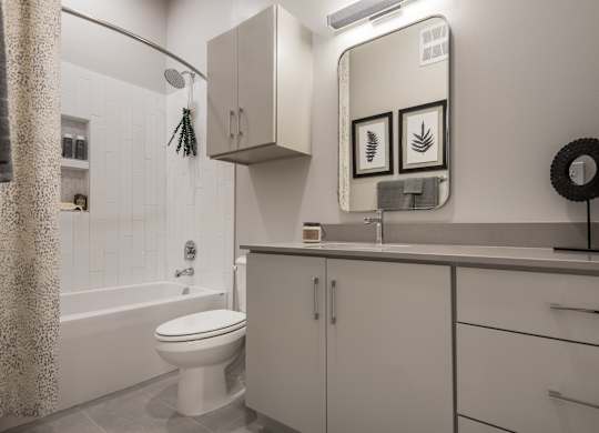 A white bathroom with a toilet, sink, and shower.