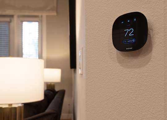 A wall-mounted thermostat shows the temperature as 72 degrees.