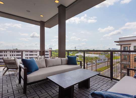 A balcony with a couch and a table.