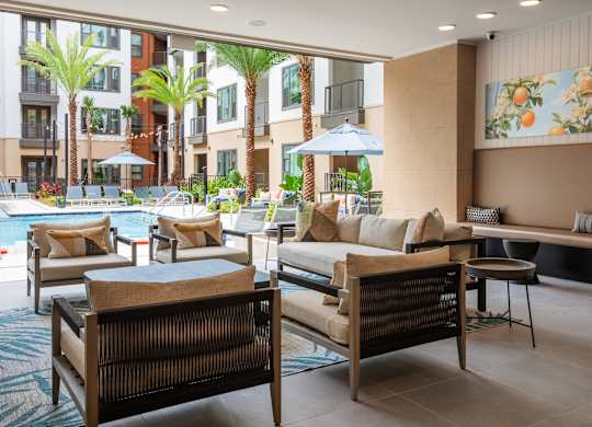 A poolside lounge area with cushioned seating and a view of the pool.