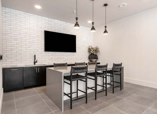 A modern kitchen with a black countertop and a white brick wall.