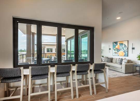 A dining room with a table and chairs in front of a large window.