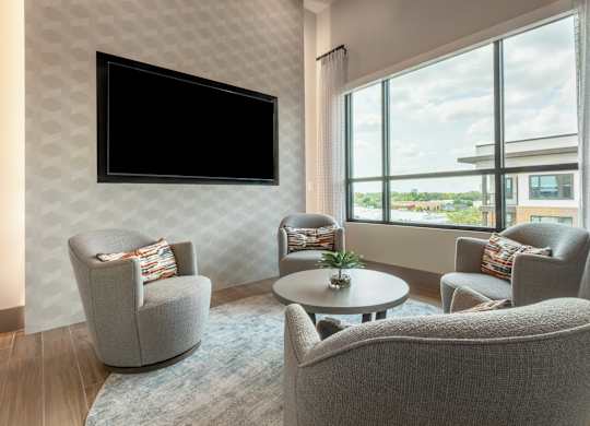 A living room with a television and comfortable seating.