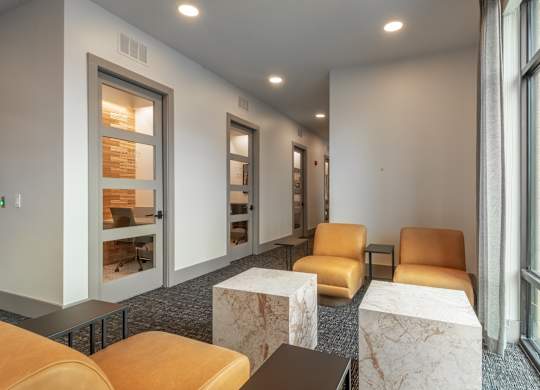 A room with a row of chairs and a table with a marble top.