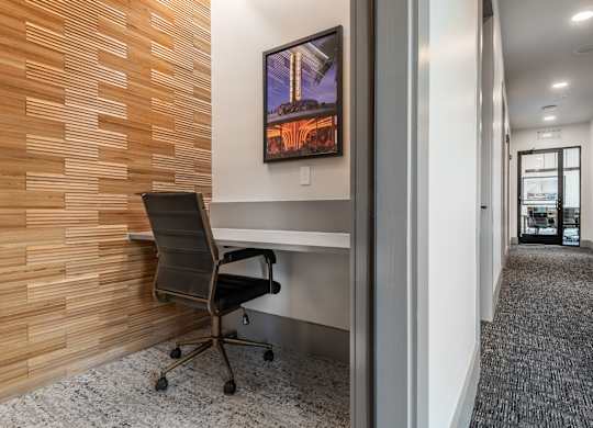 A room with a wooden wall and a black chair.