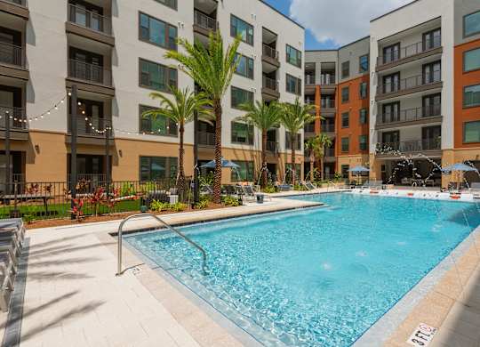 A swimming pool in front of apartment buildings.