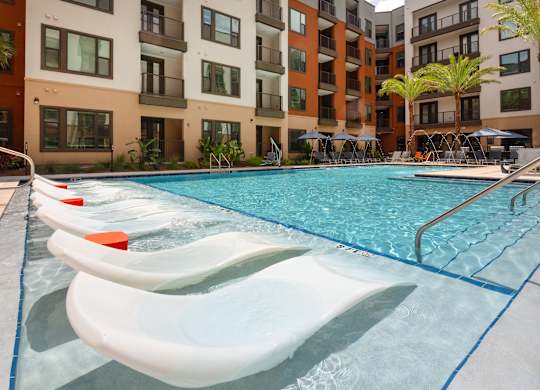 A swimming pool with a slide in front of a building.