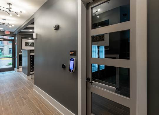 A glass door with a handle and a keypad lock.