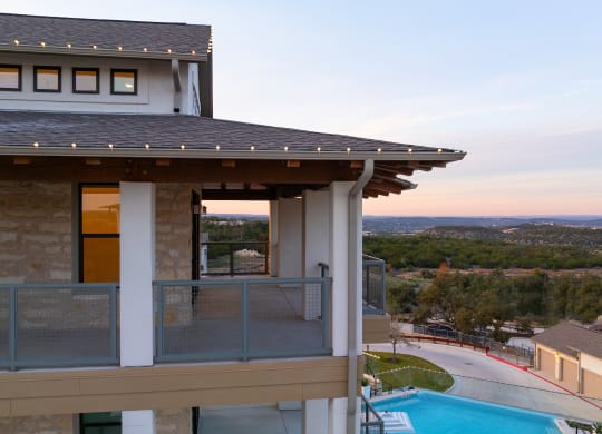 a balcony with a view of a house and a pool