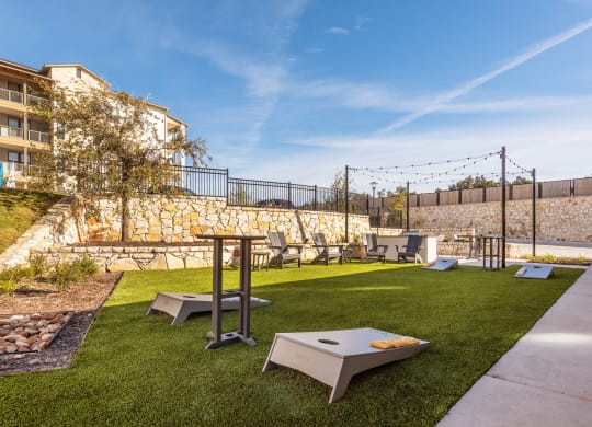 a yard with lawn furniture and tables and a stone wall
