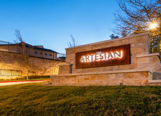 the sign for the arisian at night in front of a stone building