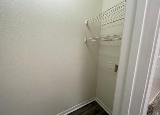A white wall with a shelf and a switchboard.