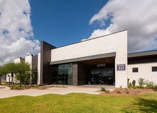 A modern building with a glass entrance and a sign that reads