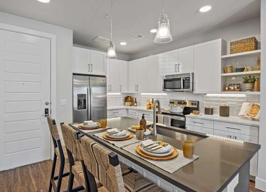 A modern kitchen with a dining table set for two.