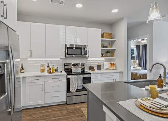 A modern kitchen with white cabinets and stainless steel appliances.