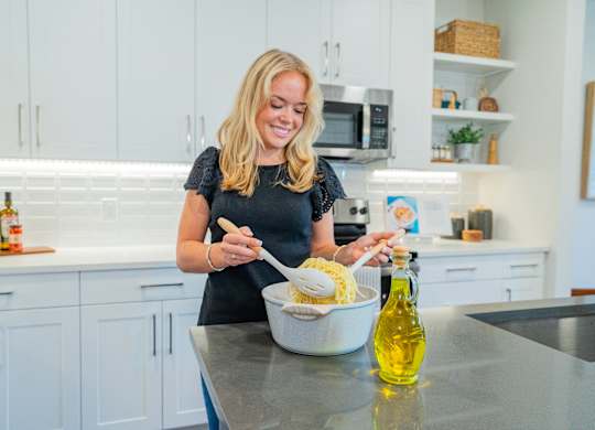 A woman is cooking in a modern kitchen.