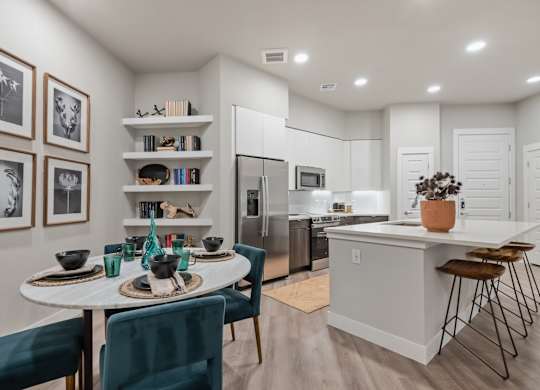 A modern kitchen with a dining table set for two.