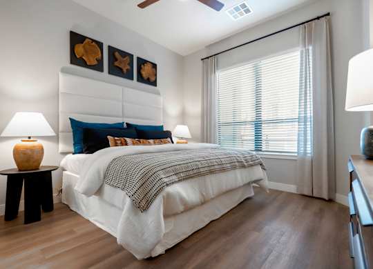 A bedroom with a large bed and a ceiling fan.