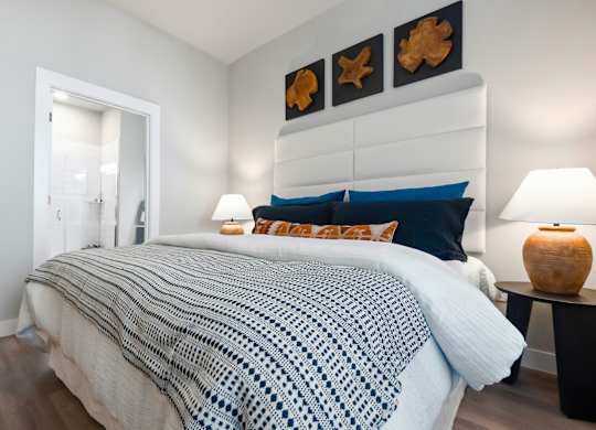 A bedroom with a bed covered in a blue and white blanket.