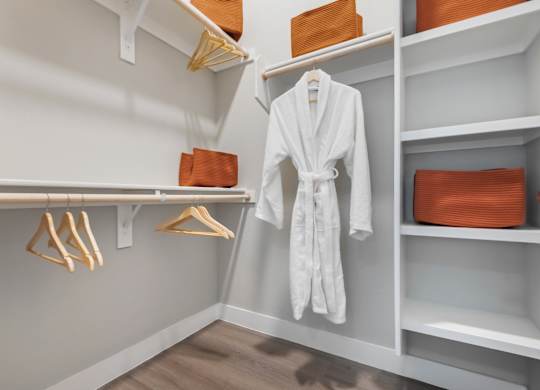 A white robe is hanging on a rack in a room.