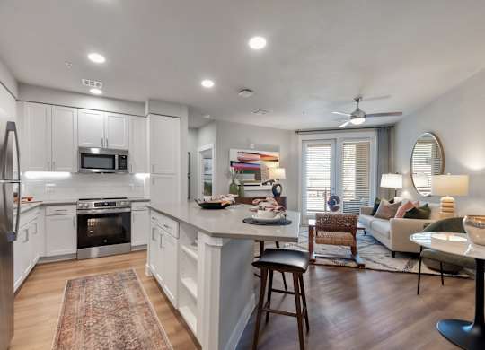 A modern kitchen with white cabinets and stainless steel appliances.