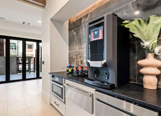 A modern kitchen with a black countertop and stainless steel appliances.