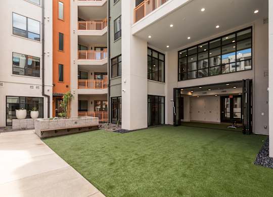 A modern building with a green lawn in front.