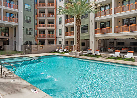 A large swimming pool in front of apartment buildings.